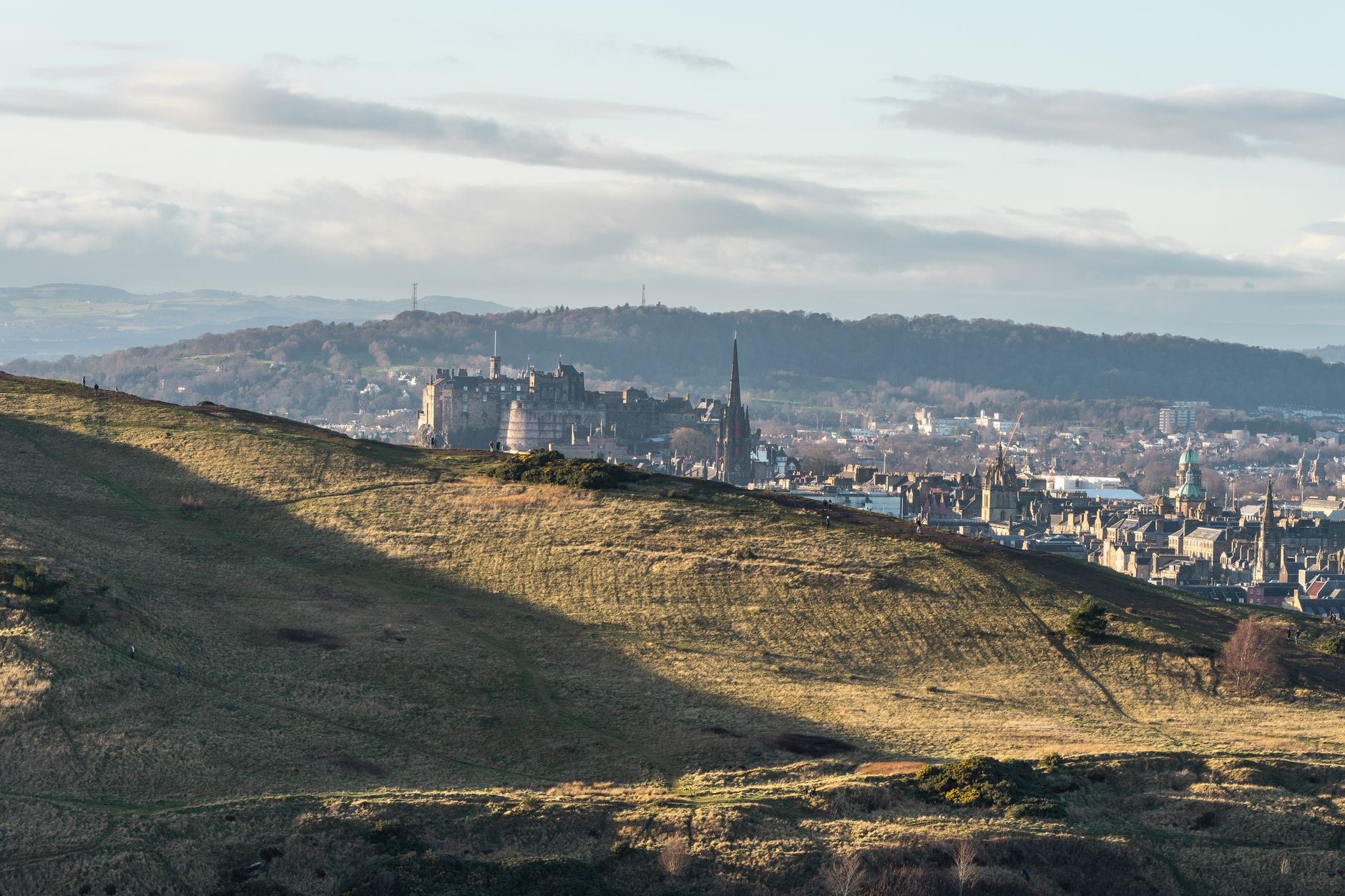 Uitzicht op het kasteel en de skyline van Edinburgh onder een bewolkte hemel