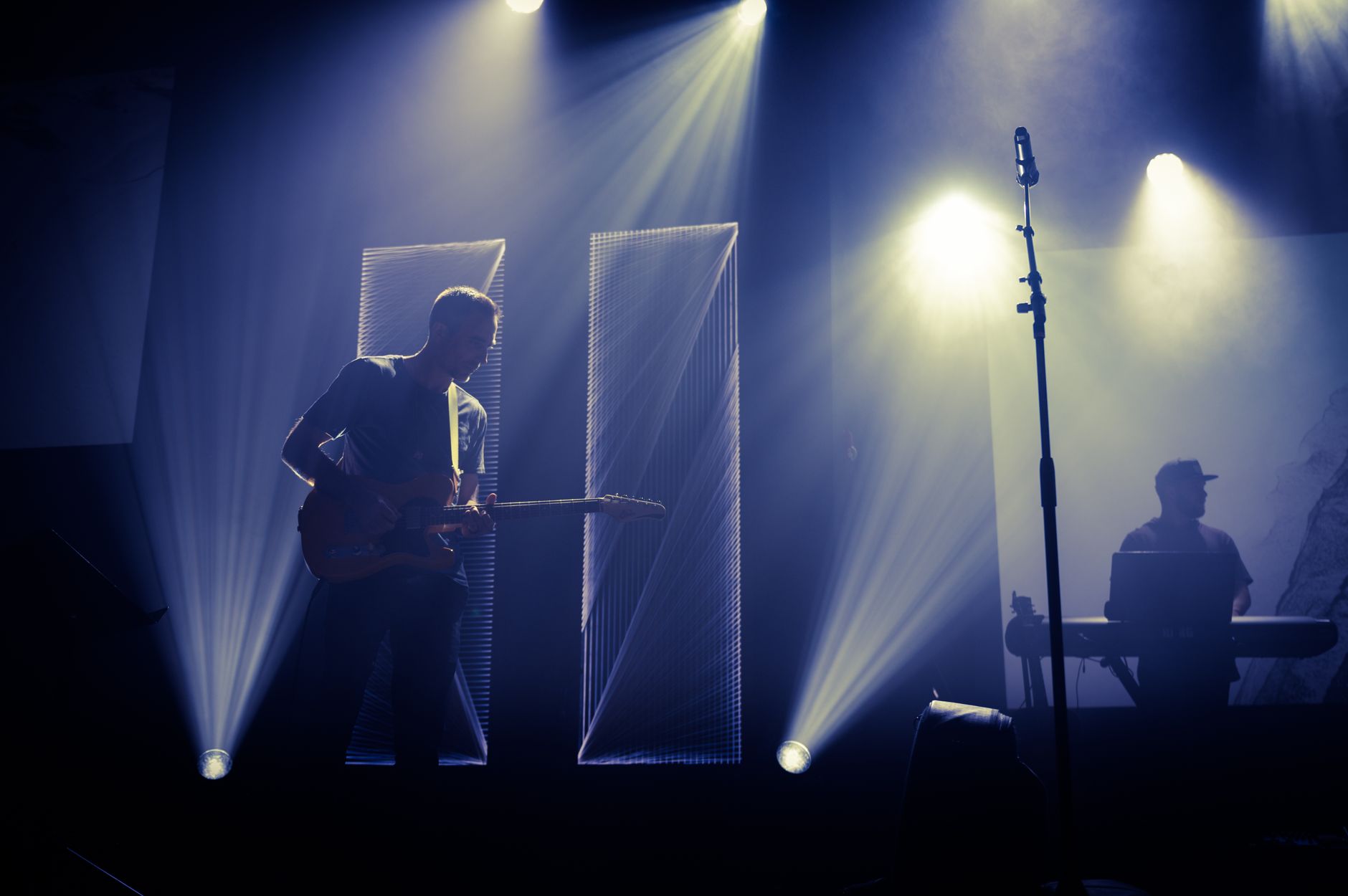 Band op een verlicht podium tijdens een liveoptreden voor een groot publiek
