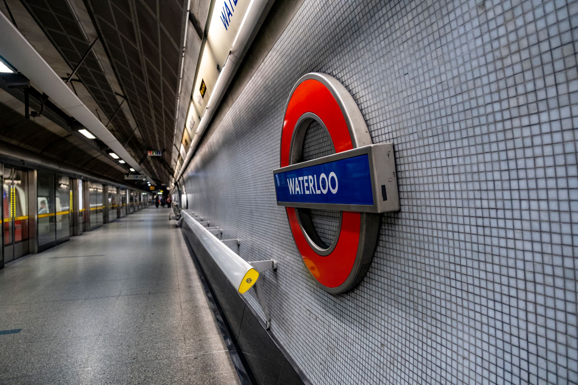Perron van de Londense metro met een aankomende tube en wachtende reizigers