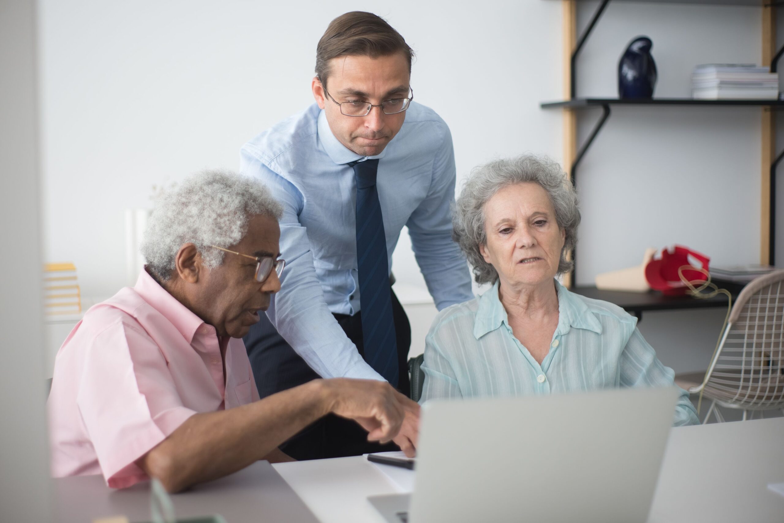 Senior koppel vult samen met hulp op een laptop een UK ETA-aanvraag in voor iemand anders