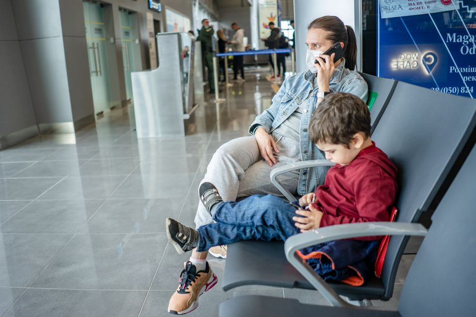 Moeder en kind wachten in de luchthaventerminal voor de vlucht naar het VK