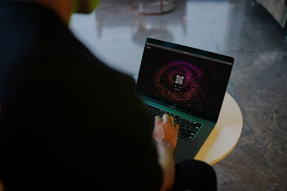 Laptop met de gov.uk ETA-aanvraagpagina naast een paspoort en een kop koffie