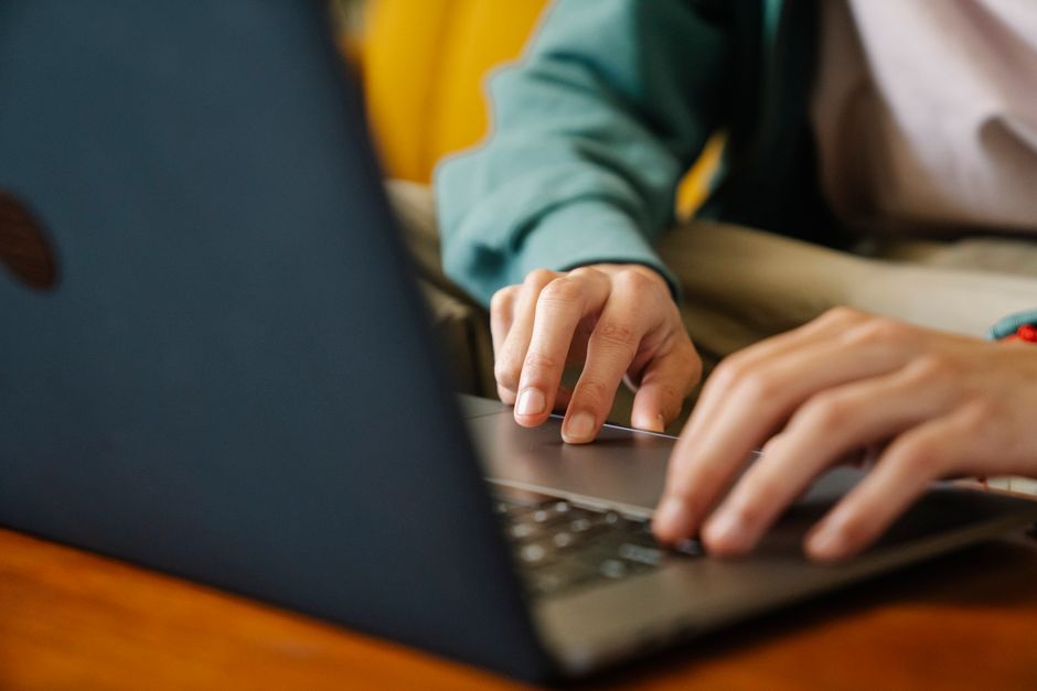 Laptop met een online aanvraagformulier en een identiteitskaart op een bureau