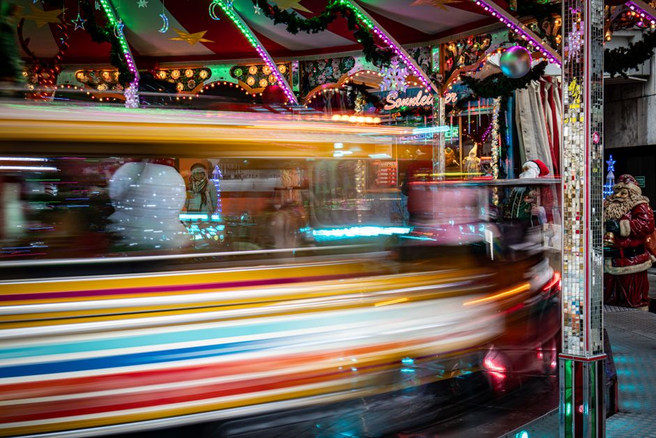 Gezin wandelt langs verlichte kerstkraampjes op een winterse avond in Londen