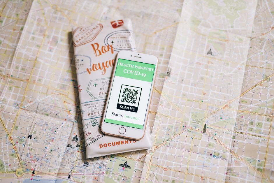 Reiziger met paspoort en telefoon vult rustig thuis de aanvraag voor een UK ETA in