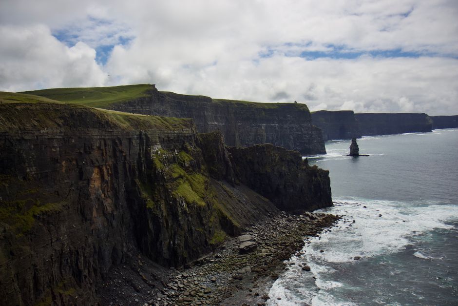 Reiziger met paspoort en kaart plant een route van Dublin naar Belfast over het Ierse eiland