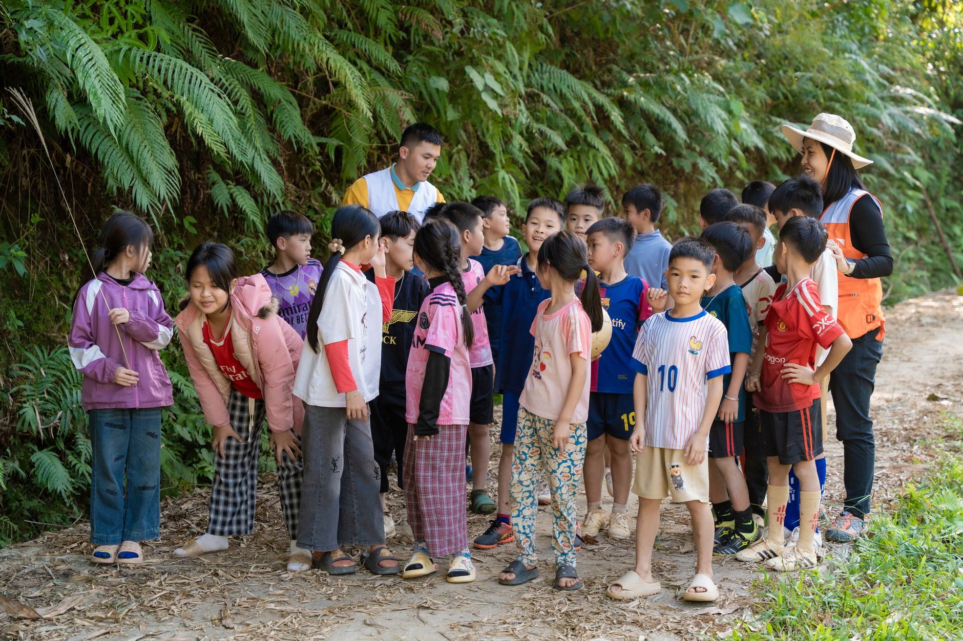 Groep schoolkinderen met begeleider wacht met rugzakken voor een schoolreis naar Engeland